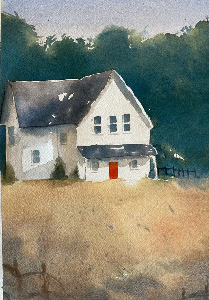 White ranch style house in front of trees